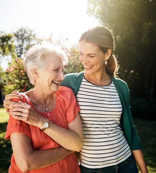 Adult child sitting with elderly parent, warm family scene